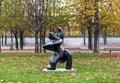 A bronze statue called Ã¢â¬ÅGreat MusicianÃ¢â¬Â with lots of fallen leaves around on a lawn in the Tuileries garden, Paris